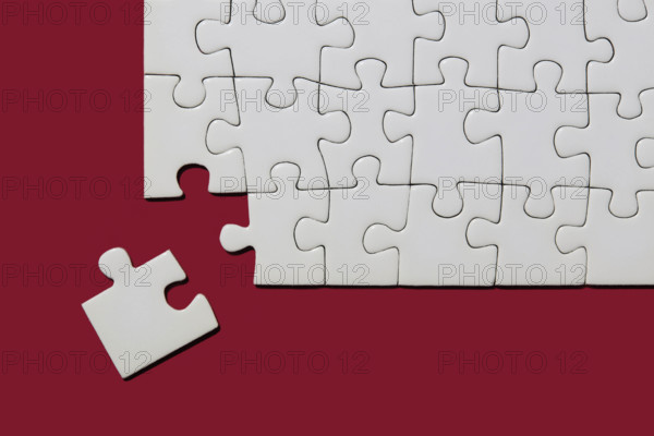 Studio shot of white puzzle pieces on red background