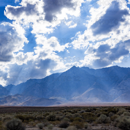USA, California, Lone Pine, Sunbeams shining through clouds above mountains