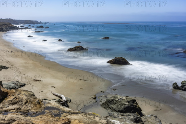 USA, California, San Simeon, Ocean waves washing sandy beach, long exposure