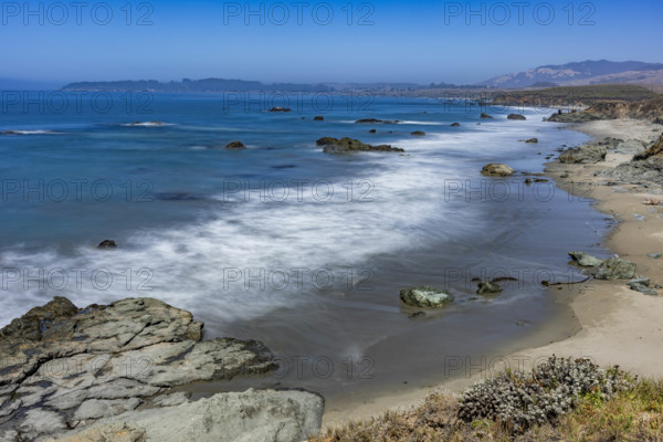 USA, California, San Simeon, Ocean waves washing sandy beach, long exposure