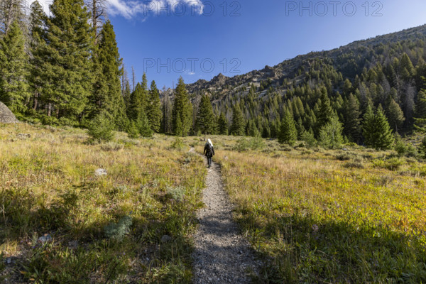 USA, Idaho, Sun Valley, Rear view of woman walking on footpath in landscape
