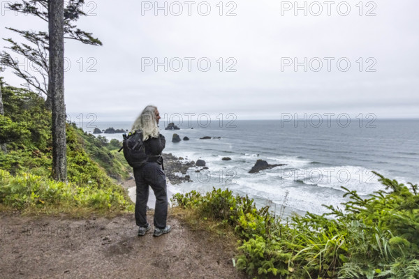 USA, Oregon, Cannon Beach, Rear view of woman standing on coastal trail