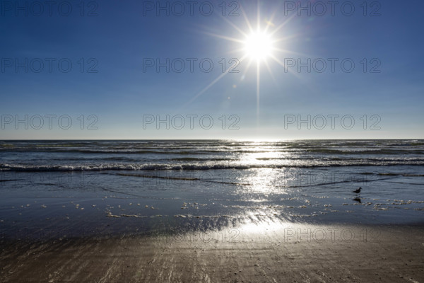 USA, Oregon, Sun setting over ocean and empty Cannon Beach