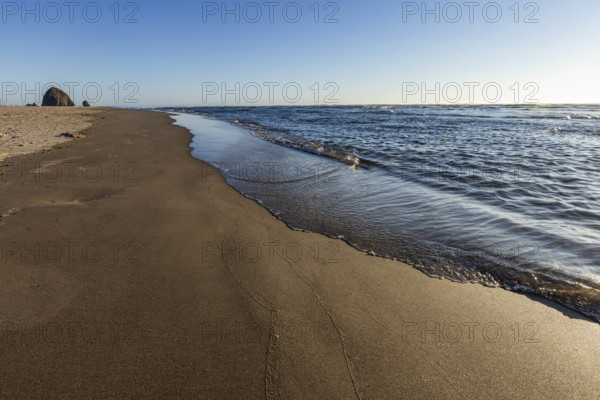 USA, Oregon, Cannon Beach, Empty beach with haystack rock in distance