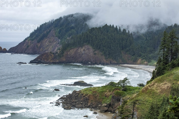 USA, Oregon, Cannon Beach, Clouds and fog over Indian Beach and headland