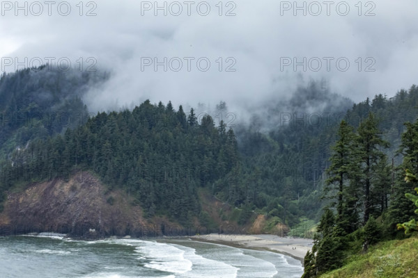 USA, Oregon, Cannon Beach, Clouds and fog over Indian Beach and headland