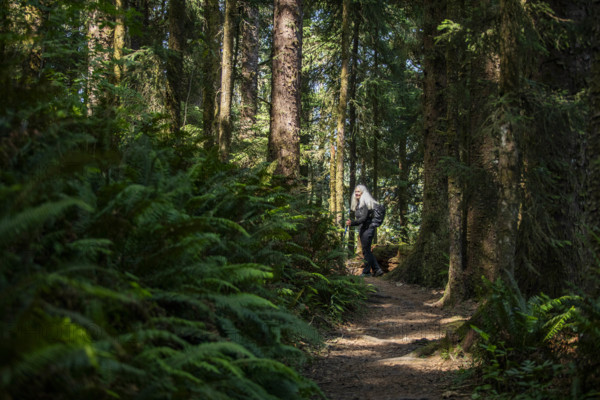 USA, Oregon, Brookings, Portrait of senior blonde hiker on coastal trail