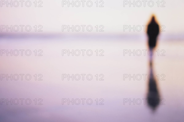 USA, New Jersey, Spring Lake, Defocussed image of woman and reflection on wet beach sand