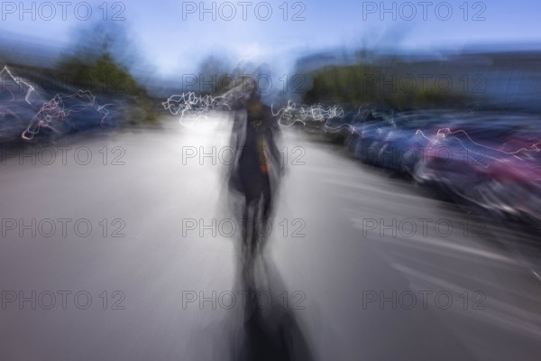 Motion blur image of woman walking in parking lot