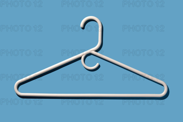 White coat hanger on blue background