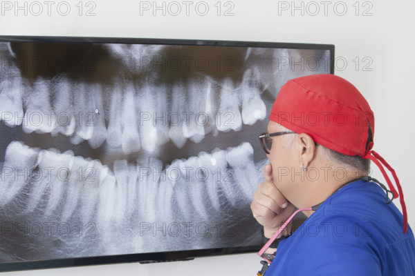 Dentist analyzing dental X-ray on screen