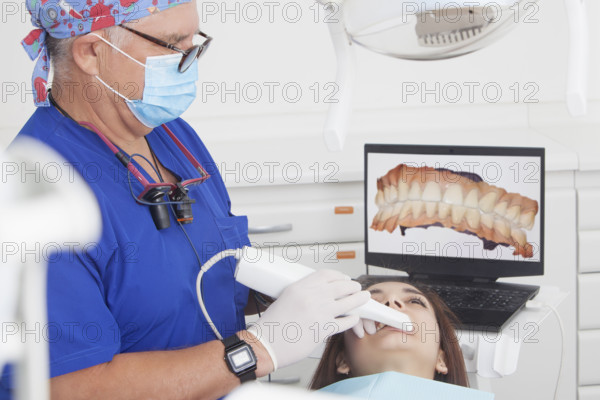 Dentist scanning female patients teeth with 3D scanner