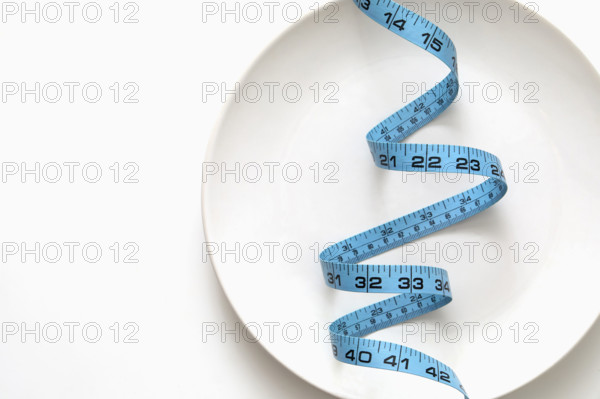 Blue tape measure on empty plate