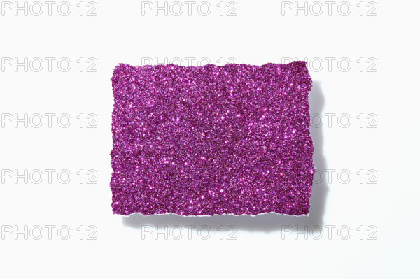 Torn pink glitter paper on white background