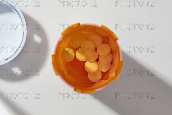 Overhead view of pills in open bottle