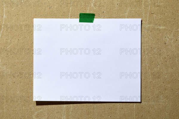 Blank paper taped to rough textured wall