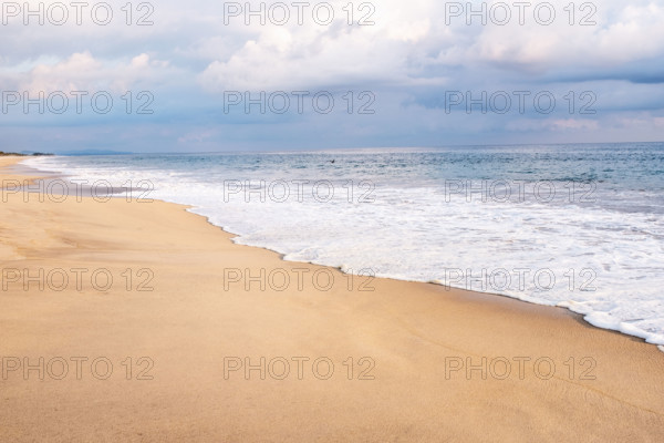 Mexico, Oaxaca State, Puerto Escondido, Costa Chica, Clouds overs ocean waves on empty beach