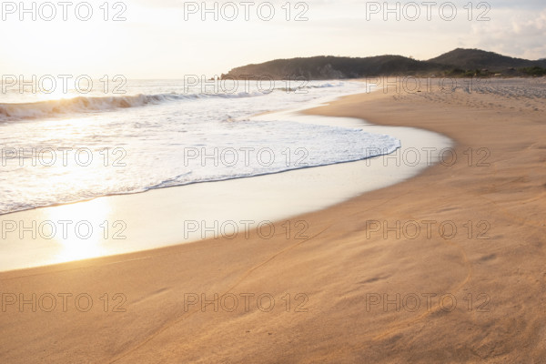 Mexico, Oaxaca State, Puerto Escondido, Costa Chica, Sunlight reflecting in ocean waves on empty beach