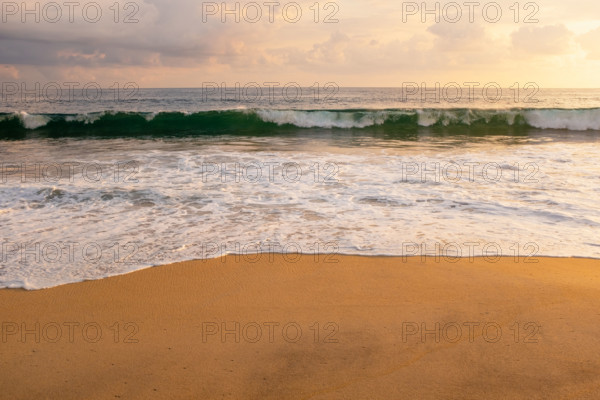 Mexico, Oaxaca State, Puerto Escondido, Costa Chica, Clouds over ocean waves on empty beach at sunset