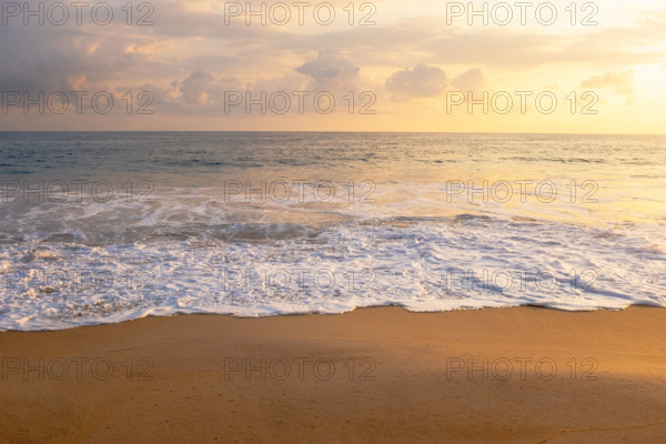Mexico, Oaxaca State, Puerto Escondido, Costa Chica, Clouds over ocean waves on empty beach at sunset