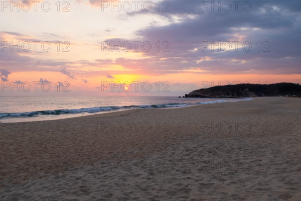 Mexico, Oaxaca State, Puerto Escondido, Costa Chica, Sun setting over ocean and empty beach
