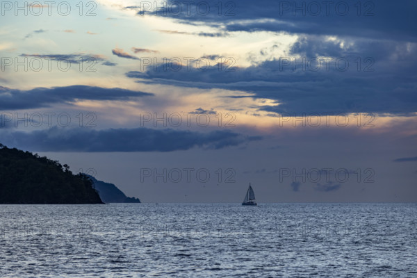 Costa Rica, Guanacaste, Playa Flamingo, Silhouette of sailboat on sea horizon at sunset