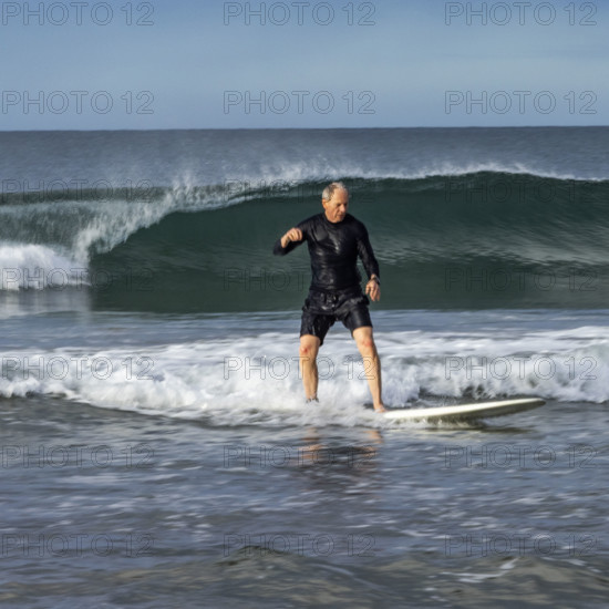 Costa Rica, Guanacaste, Playa Grande, Senior man surfing on sea wave