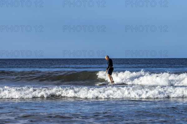 Costa Rica, Guanacaste, Playa Grande, Senior man surfing on sea wave