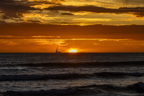 Costa Rica, Guanacaste, Playa Grande, Silhouette of sailboat on sea horizon at sunset