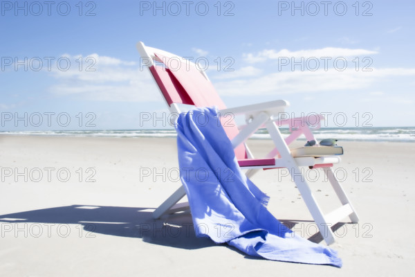 Empty chair with blue blanket on beach