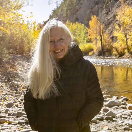 USA, Idaho, Bellevue, Portrait of senior blonde woman at river in autumn