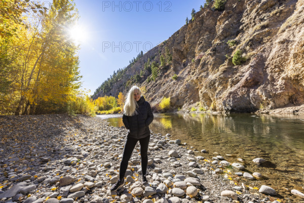 USA, Idaho, Bellevue, Portrait of senior blonde woman at river in autumn