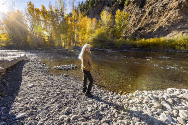 USA, Idaho, Hailey, Portrait of senior blonde woman at river in autumn