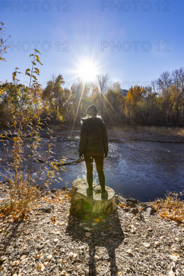 USA, Idaho, Bellevue, Rear view of woman facing Big Wood River on sunny autumn day