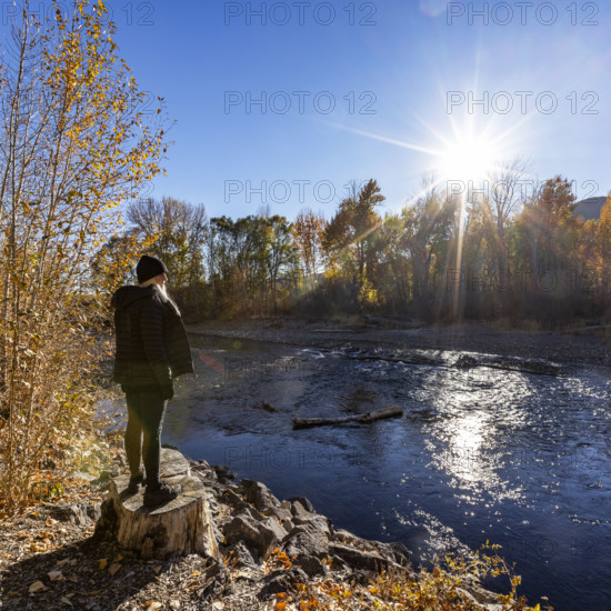 USA, Idaho, Bellevue, Woman facing Big Wood River on sunny autumn day