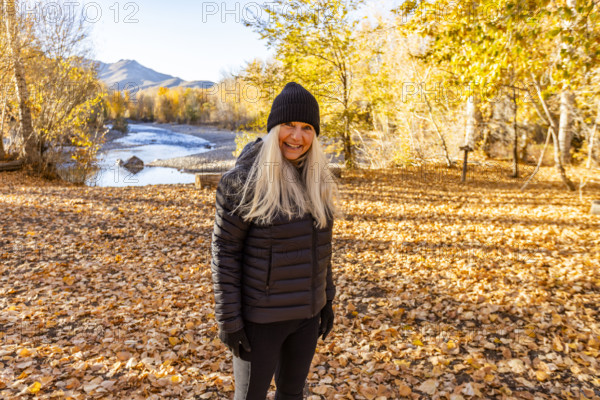 USA, Idaho, Bellevue, Portrait of smiling woman near Big Wood River in autumn