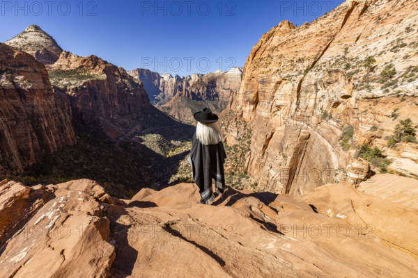 USA, Utah, Zion National Park, Rear view of woman in poncho and hat at Zion Canyon Overlook