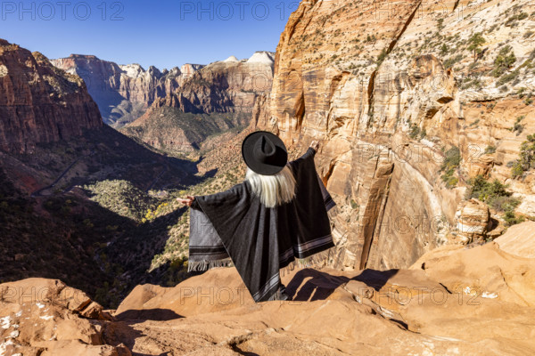 USA, Utah, Zion National Park, Rear view of woman in poncho and hat at Zion Canyon Overlook