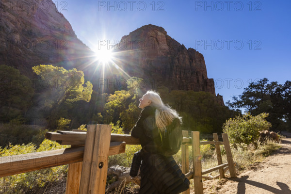 USA, Utah, Zion National Park, Senior woman leaning on fence on trail to Angels Landing