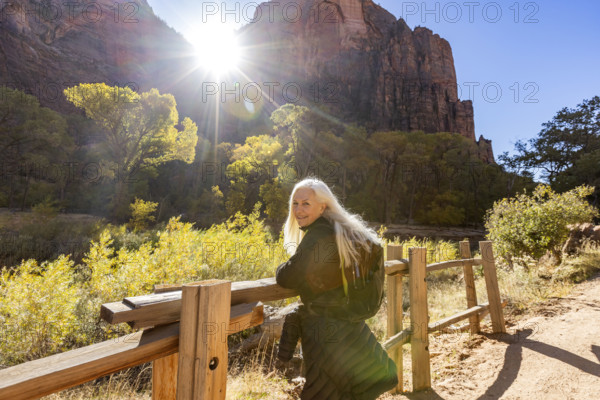 USA, Utah, Zion National Park, Senior woman leaning on fence on trail to Angels Landing