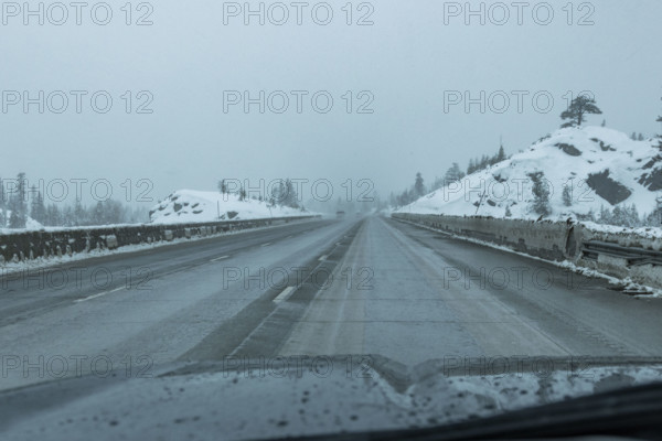 USA, California, Donner Pass, Empty highway seen from car during rain in winter
