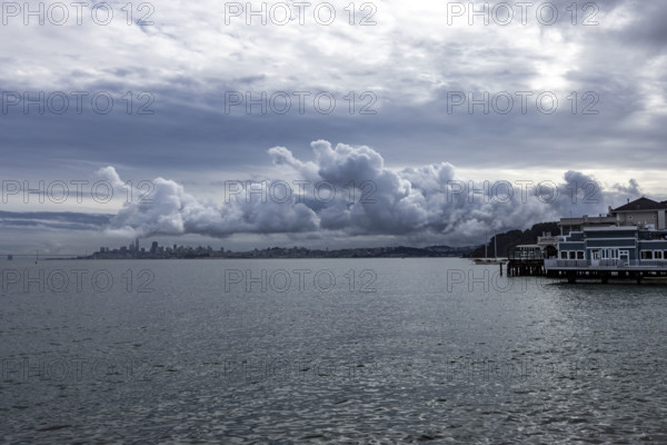 USA, California, Sausalito, Puffy clouds above city skyline across bay