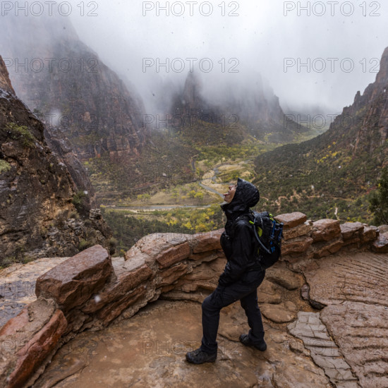 USA, Utah, Zion National Park, Female hiker catching snowflakes on tongue on trail to Angels Landing