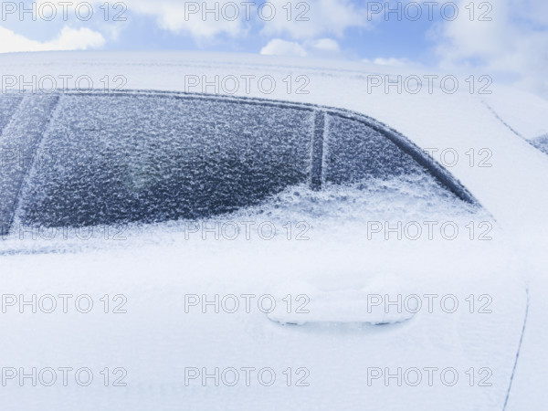 Close-up of compact SUV frozen in snow and ice