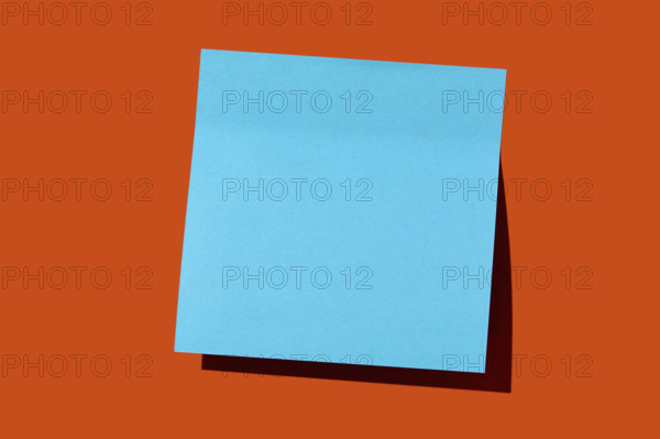 Blank blue post it note on orange background