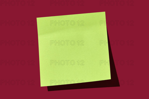 Blank green post it note on red background