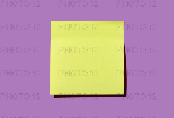 Blank yellow post it note on purple background
