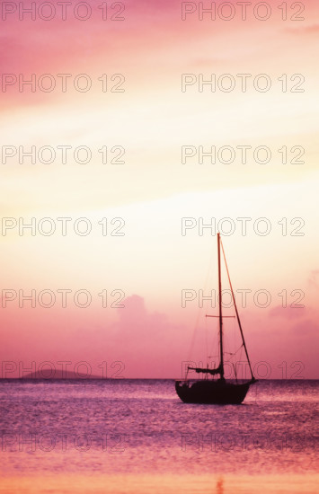 USA, United States Virgin Islands, St. Thomas, Silhouette of sailboat on Pillsbury Sound at sunrise