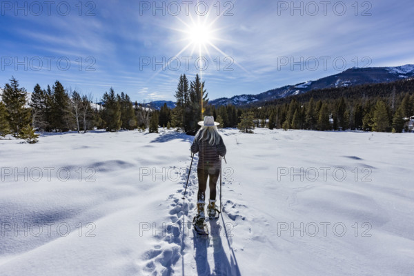 USA, Idaho, Sun Valley, Rear view of woman snowshoeing on sunny winter day