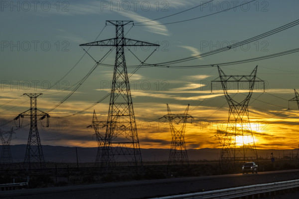 USA, California, Barstow, Electricity pylons and power lines at sunset